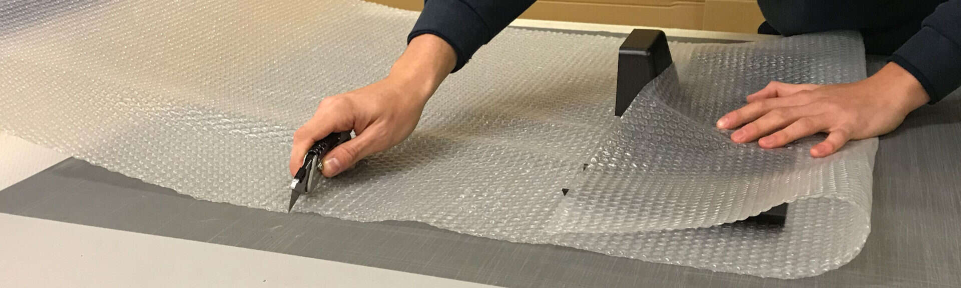 Worker Cutting Bubble Wrap