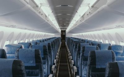 View down isle of airplane with blue seats