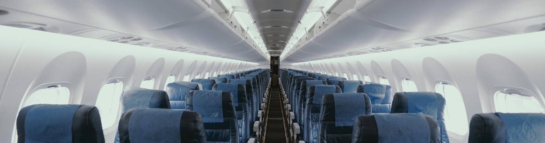 View down isle of airplane with blue seats